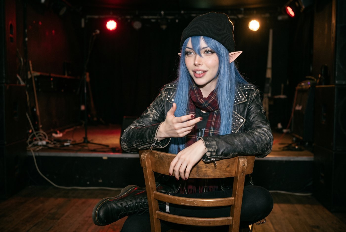 White Rose assise sur une chaise en bois dans le club vide après le concert, veste en cuir et écharpe écossaise, en train de raconter quelque chose